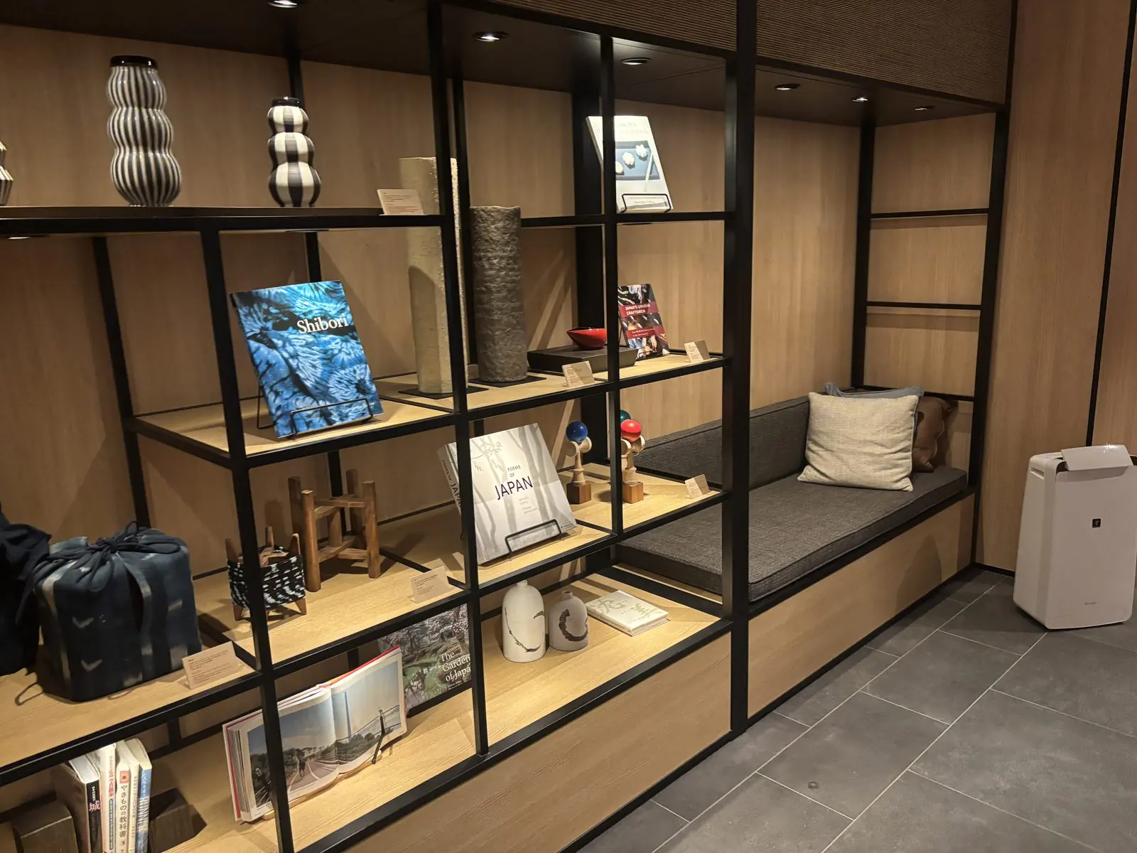 ロビーの一角にある工芸品と本を並べた棚。藍染めの布、陶器、けん玉、日本文化の洋書などが並ぶ