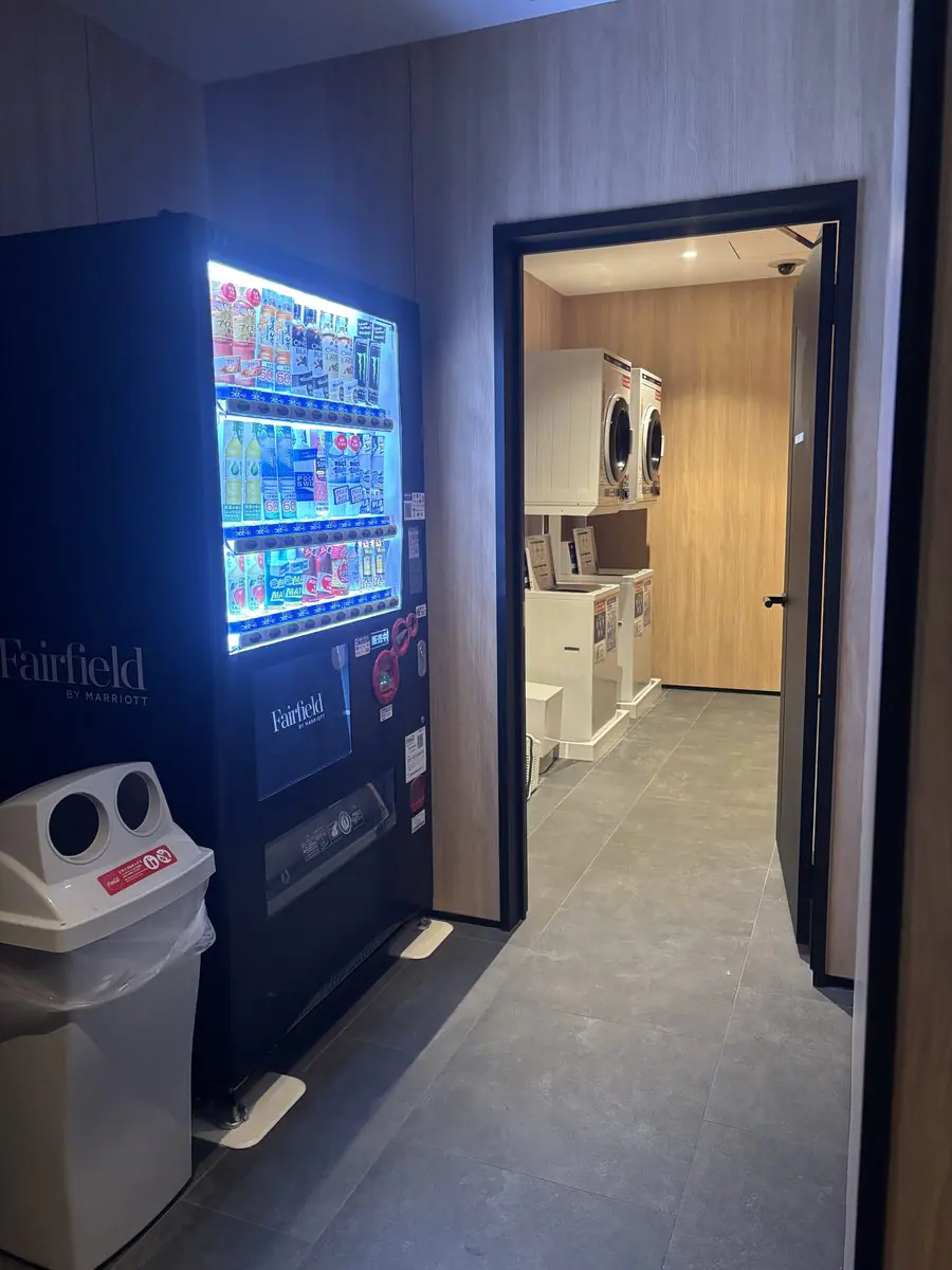 Fairfieldロゴ入りの自動販売機と、その奥にあるコインランドリー。洗濯乾燥機が2台並んでいる