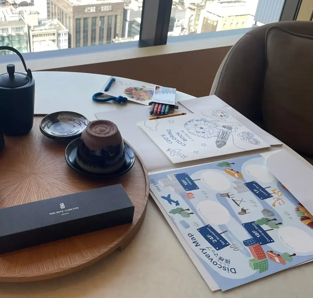 ウェルカムの茶器のセット。木のトレイに急須と茶碗、リッツ・カールトンのロゴ入りの箱が載っている