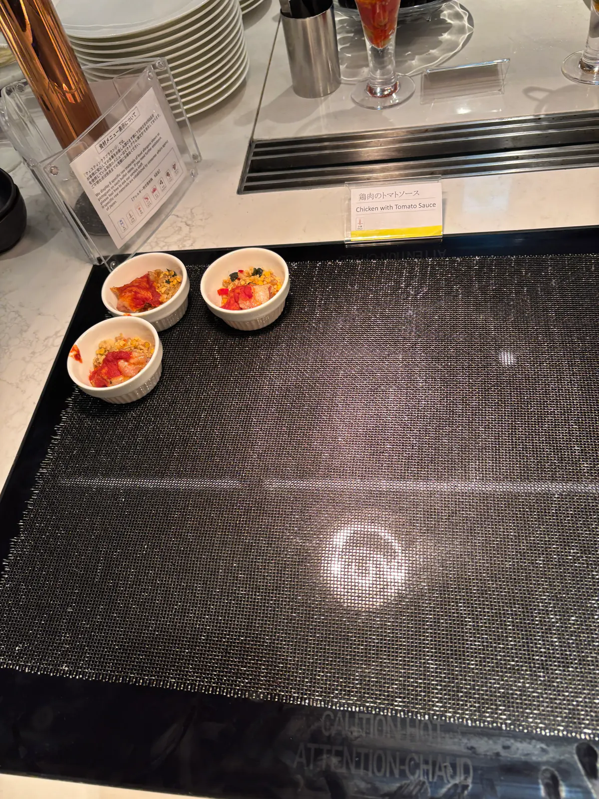 黒い天板のテーブルに置かれた小鉢。トマトや野菜を使った前菜が少量ずつ盛られている